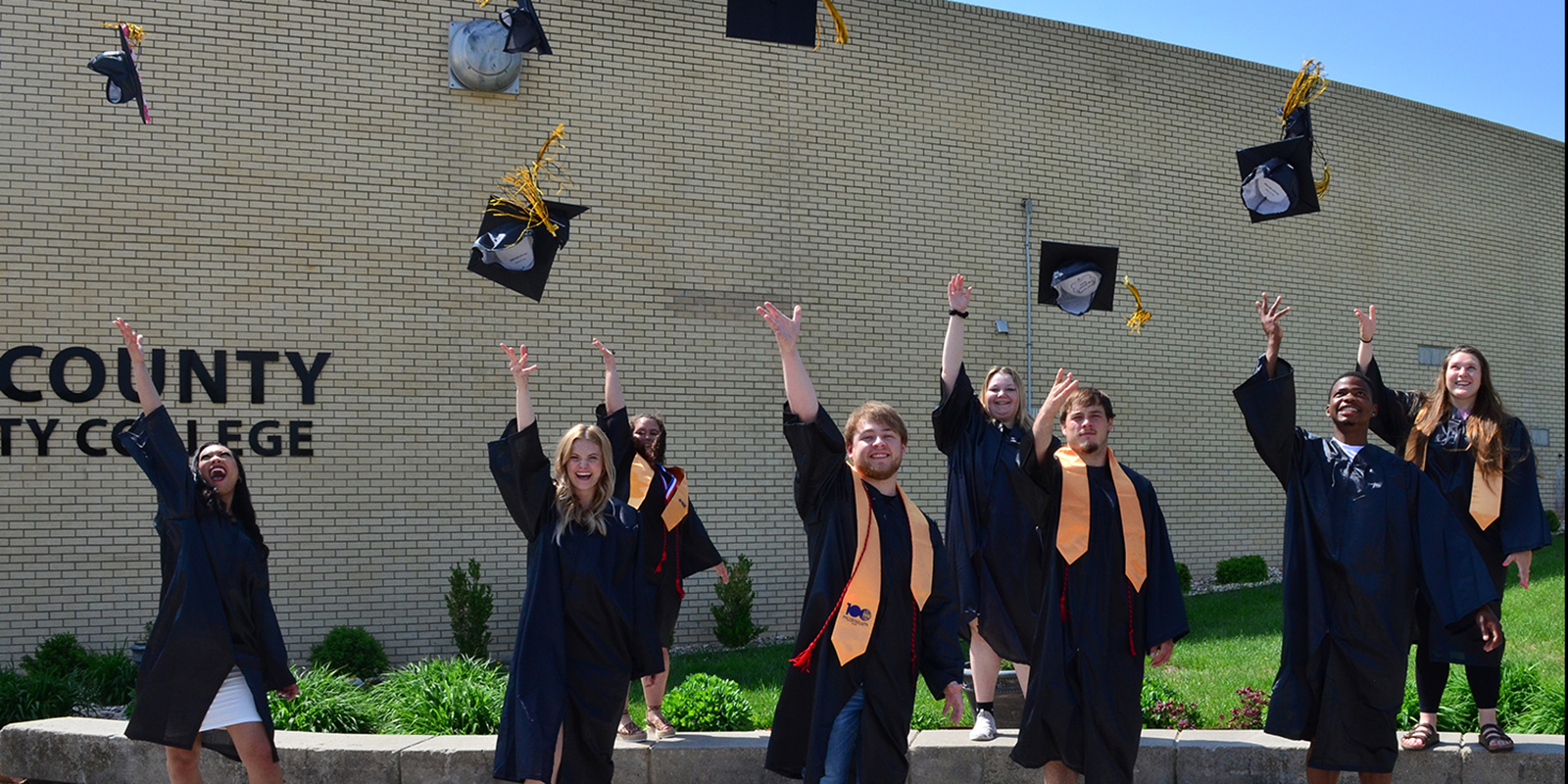 A photo of graduates throwing their caps.